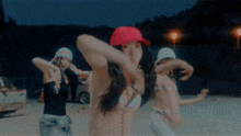 a woman wearing a red hat is dancing with two other girls