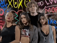 a group of people are posing in front of a sign that says xoxo