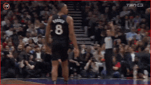 a basketball player with the number 5 on his jersey is walking on the court