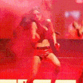 a woman singing into a microphone on a stage with a red background