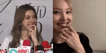 a woman with a ring on her finger smiles next to another woman with a ring on her finger