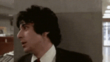a man in a suit and tie is looking to his left