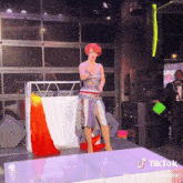 a woman with red hair is standing on a stage with a tik tok watermark