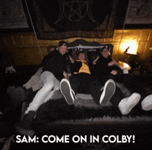 a group of people laying on a bed with the words " sam come on in colby " above them