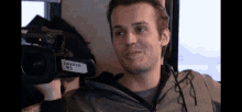 a man holds a camera with a label that says dakota # 1 on it