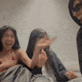 a group of people are sitting on a couch laughing and having fun .