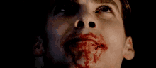 a close up of a man 's face with blood on it