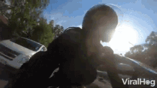 a person wearing a helmet is riding a motorcycle in front of a car .