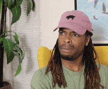 a man wearing a pink hat with a black pig on it