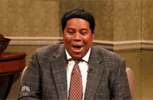 a man in a suit and tie is sitting in a chair