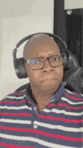 a man wearing a striped shirt and headphones is making a funny face .