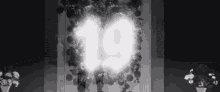 a black and white photo of a wall with flowers and the number 19 .