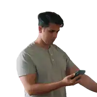 a man in a grey shirt is holding a cell phone