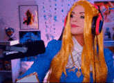 a woman wearing a blue dress and red headphones is standing in front of a shure microphone