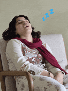 a woman is sleeping in a chair with a blue zzz sign above her