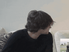 a man sitting on a couch looking at something