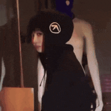 a woman wearing a black hoodie with an arrow pointing to the right