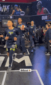 a group of female basketball players are running on a court in front of a sign that says atl