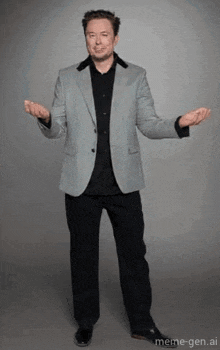 a man in a suit and black shirt is standing with his arms outstretched