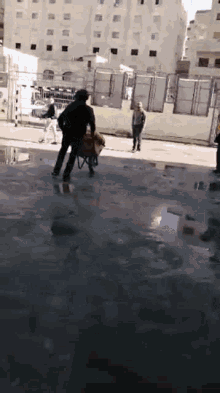 a man is pushing a wheelbarrow in a puddle
