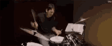 a man is playing drums in a dark room in a dark room .