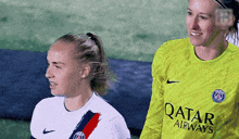 a female soccer player wearing a yellow qatar airways jersey