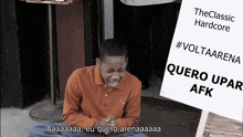 a boy sitting on the ground holding a sign that says #voltaarena