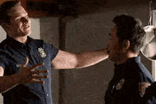 a man in a blue shirt is hugging another man in a blue shirt .