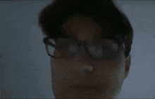 a close up of a person 's face with glasses and a surprised look on his face .