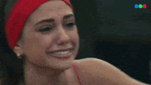 a close up of a woman wearing a red headband and smiling .
