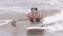 a man wearing a monkey mask is sitting on a surfboard in the ocean