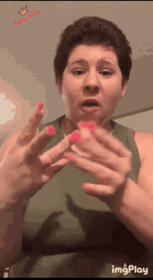 a woman in a green tank top has pink nails and the words betty coop on the bottom
