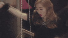 a woman wearing a black dress and red lipstick is standing in front of a mirror