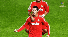 a soccer player wearing a red bwin jersey