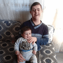 a boy is holding a baby who is wearing a shirt that says " free for today "