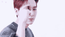 a young man with red hair is holding something in front of his face