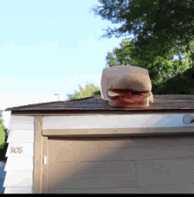 a sandwich is sitting on the roof of a garage with the number 908 on the side