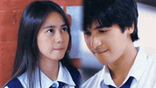 a boy and a girl are looking into each other 's eyes .
