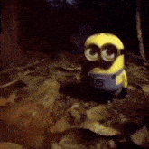 a minion is standing in the woods with his eyes closed .