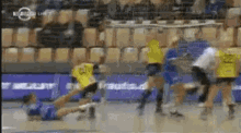 a group of people are playing a game of handball and one of them has the number 25 on his jersey