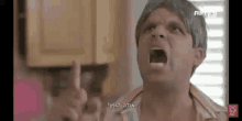 a man with his mouth open is yelling in a kitchen