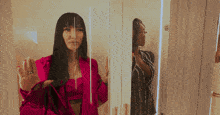 a woman in a pink jacket is standing next to another woman in a black dress