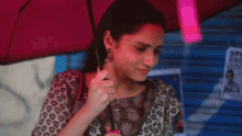 a woman is holding a red umbrella in front of a sign that says spoken english .