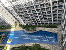 an aerial view of a building with a large swimming pool in the middle