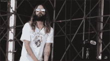 a man with long hair and a beard wearing sunglasses and a shirt that says le reiseh