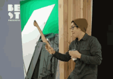 a man holding a piece of wood in front of a green screen that says best products