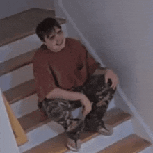 a man is sitting on a set of stairs with his mouth open