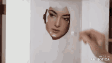 a person is painting a woman 's face on a piece of paper