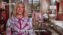 a woman in a floral dress says it was kinda shocking in front of a living room