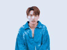 a young man in a blue shirt is making a face